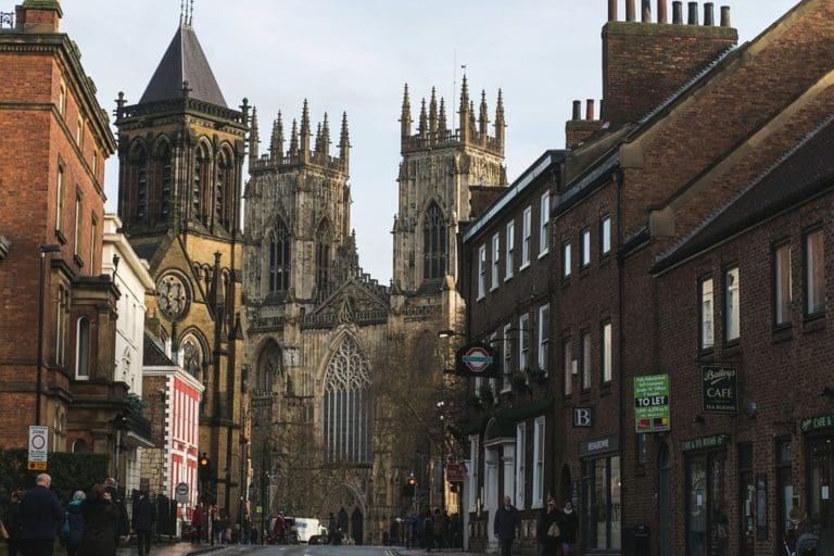 View of York Minster from ground level, the Minster is framed by both side of an adjecent street